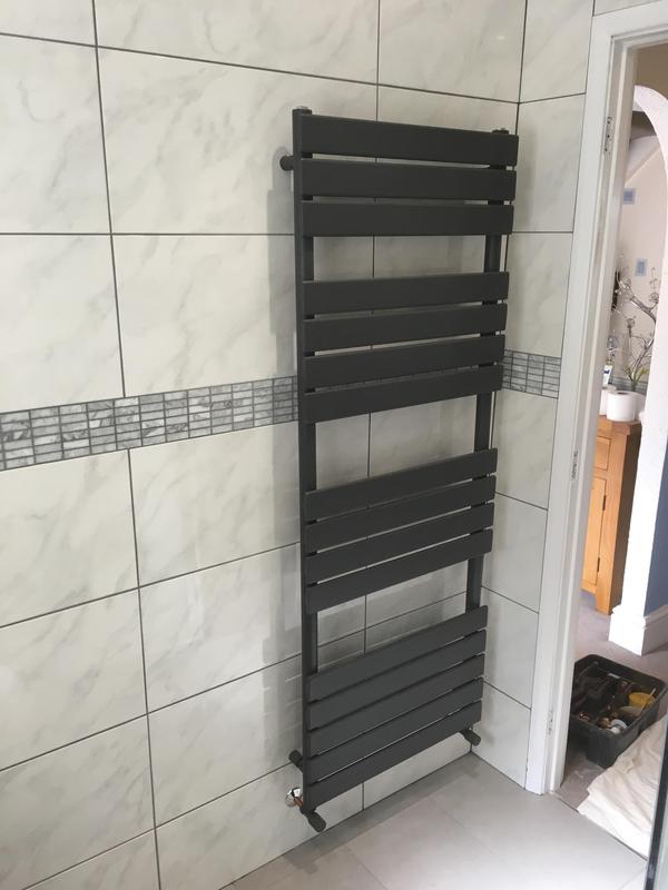 Anthracite designer vertical towel radiator installed in tiled bathroom