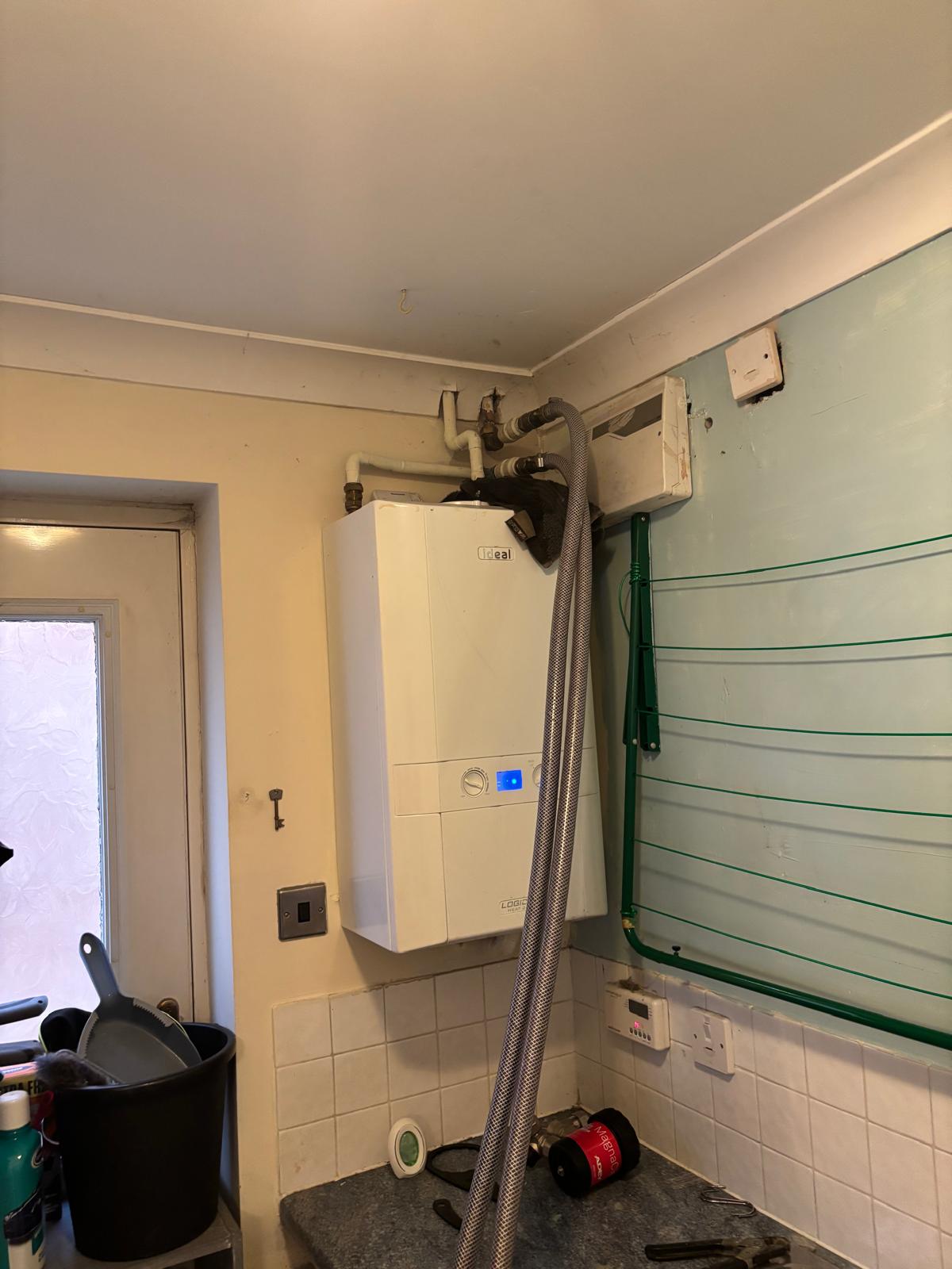 Power flush rig connected to an Ideal Logic combi boiler with Magnaclean filter on the worktop