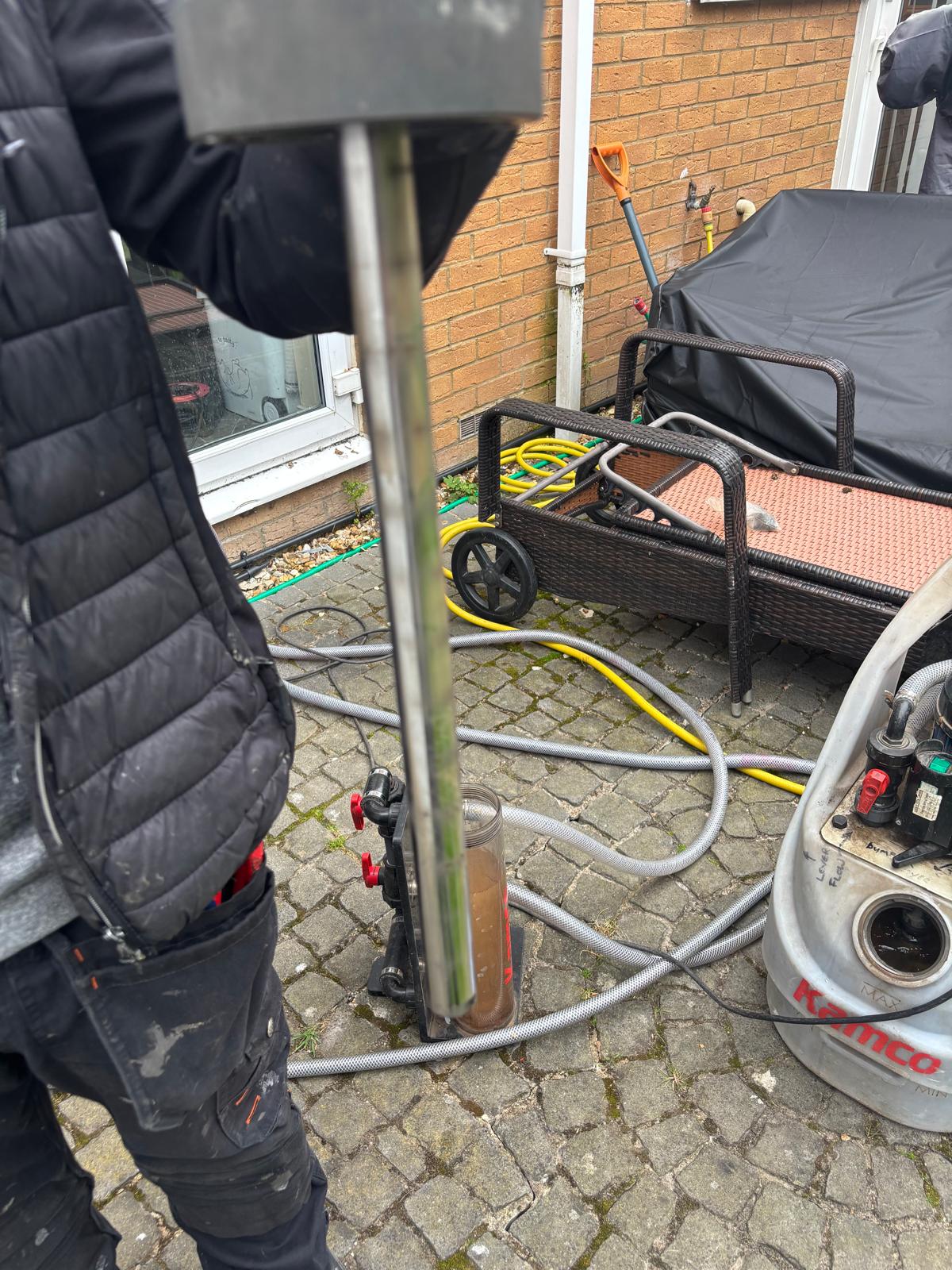 Detailed view of the Kamco power flush pump connections and heating system manifold during a flush